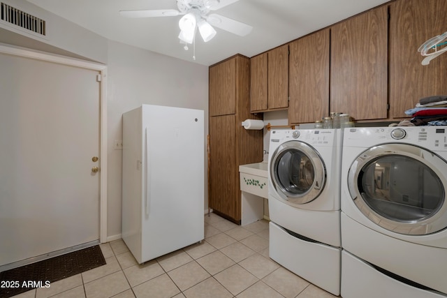 washroom featuring cabinet space, visible vents, washer and clothes dryer, and light tile patterned flooring