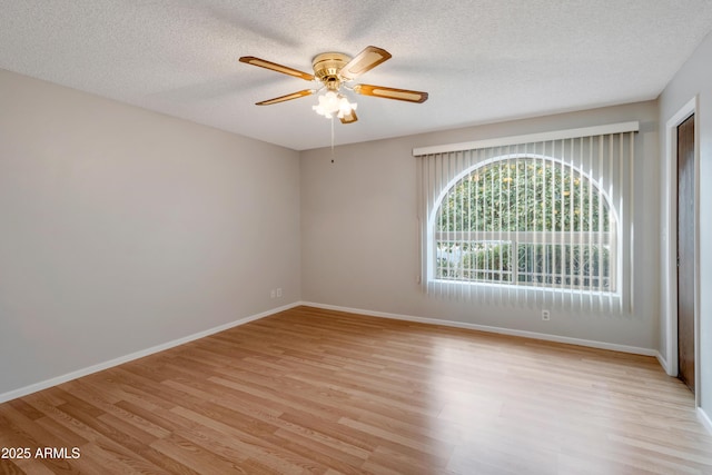 empty room featuring light wood-style floors, ceiling fan, a textured ceiling, and baseboards