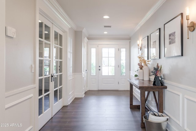 foyer with visible vents, wainscoting, dark wood-style floors, ornamental molding, and french doors