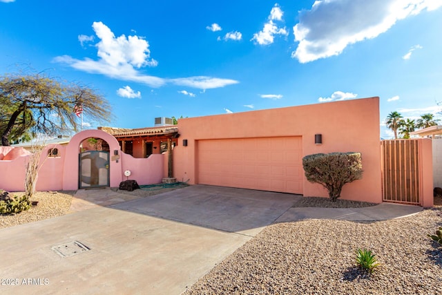 2843 E Captain Dreyfus Ave, Phoenix, AZ 85032 - pueblo-style house with stucco siding, a garage, concrete driveway, a gate, and a tile roof