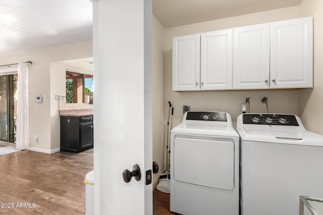 2843 E Captain Dreyfus Ave, Phoenix, AZ 85032 - laundry room with cabinet space, washer and clothes dryer, and light wood-style floors