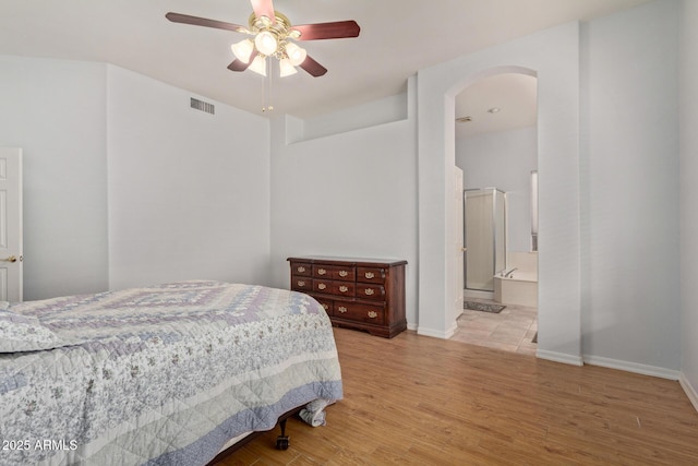 bedroom with connected bathroom, light wood-type flooring, and ceiling fan