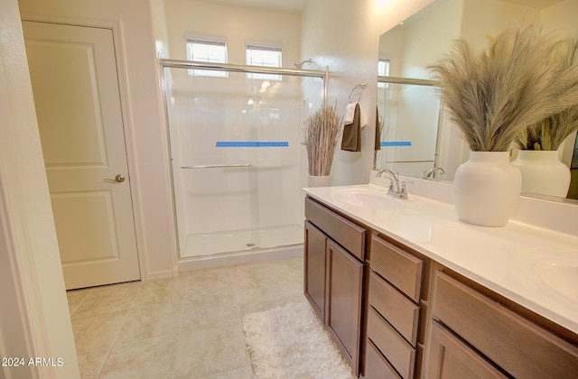 bathroom featuring double sink vanity, tile patterned flooring, and an enclosed shower