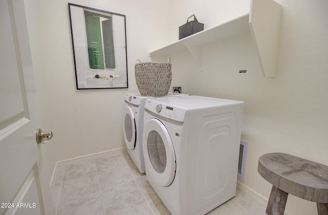 clothes washing area featuring light tile patterned flooring and separate washer and dryer