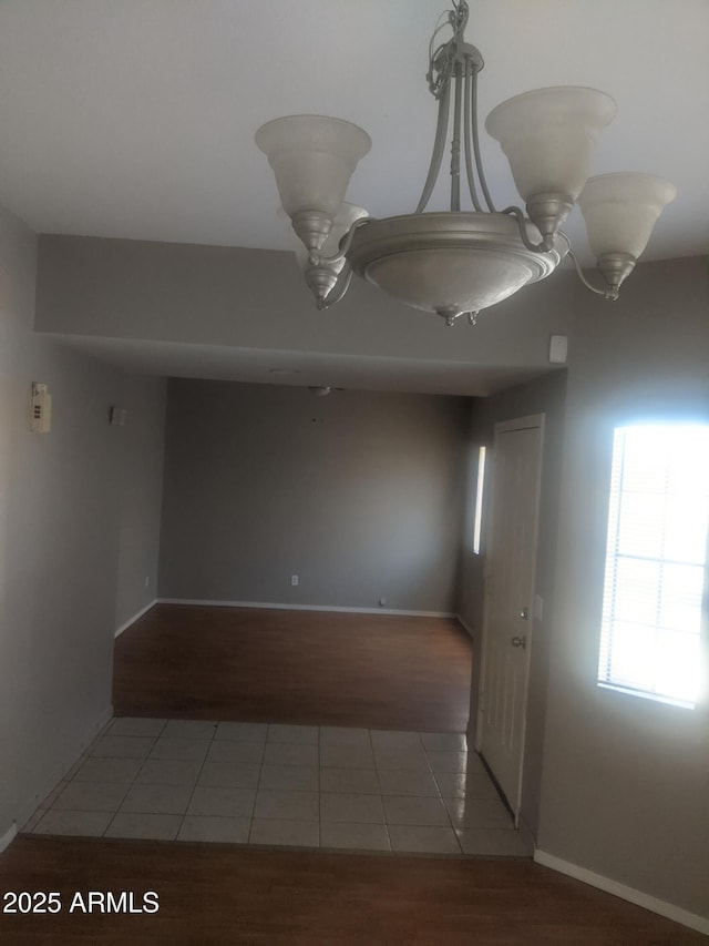 empty room with tile patterned flooring and baseboards