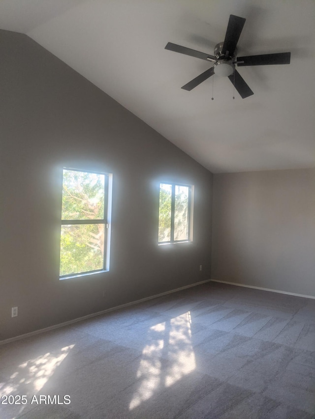 spare room with high vaulted ceiling, plenty of natural light, baseboards, and ceiling fan