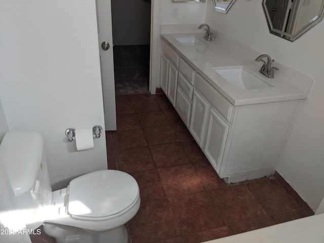 bathroom featuring tile patterned floors, a sink, toilet, and double vanity