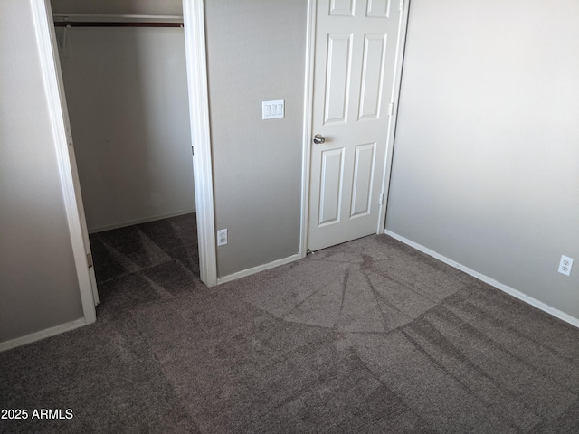 unfurnished bedroom with carpet floors, a closet, and baseboards