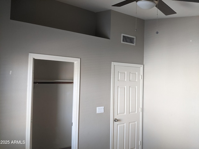 unfurnished bedroom featuring high vaulted ceiling, a closet, visible vents, and ceiling fan