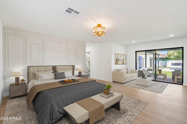 bedroom featuring access to exterior and light hardwood / wood-style flooring