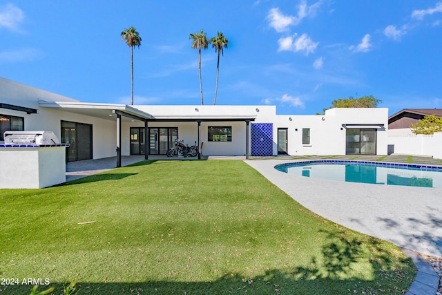 rear view of property with a yard and a patio