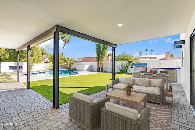 view of patio / terrace featuring an outdoor living space, exterior kitchen, area for grilling, and a fenced in pool