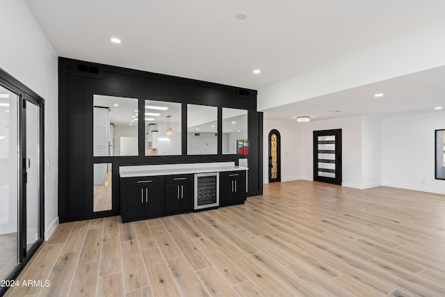 bar featuring wine cooler and light hardwood / wood-style floors