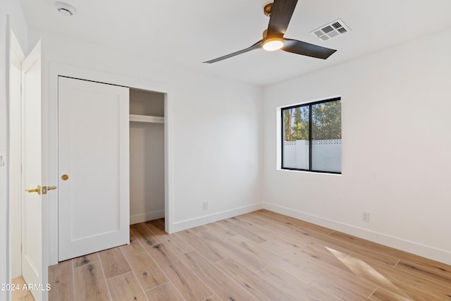 unfurnished bedroom with ceiling fan, a closet, and light hardwood / wood-style flooring