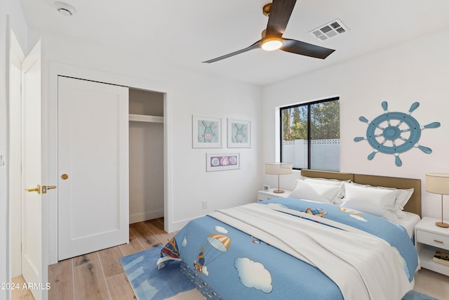 bedroom featuring ceiling fan, light hardwood / wood-style floors, and a closet