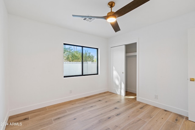 unfurnished bedroom with light hardwood / wood-style floors, a closet, and ceiling fan