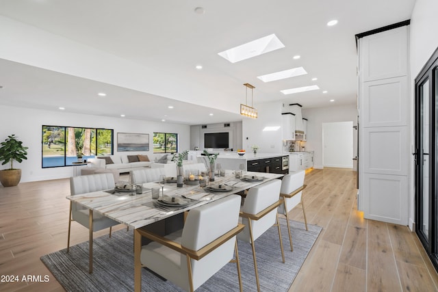 dining room featuring a skylight and light hardwood / wood-style flooring