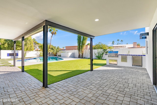 view of patio / terrace featuring a fenced in pool, an outdoor kitchen, and area for grilling