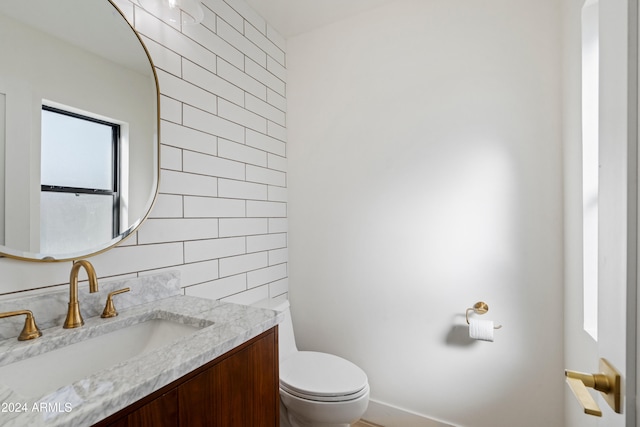 bathroom with vanity, backsplash, and toilet