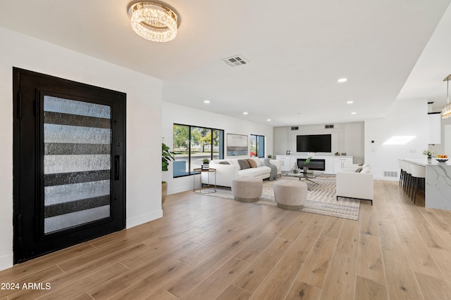 living room with light hardwood / wood-style flooring and a notable chandelier