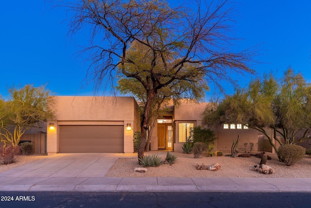 pueblo-style house featuring a garage