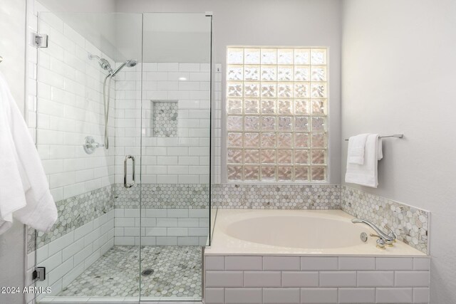 bathroom featuring shower with separate bathtub