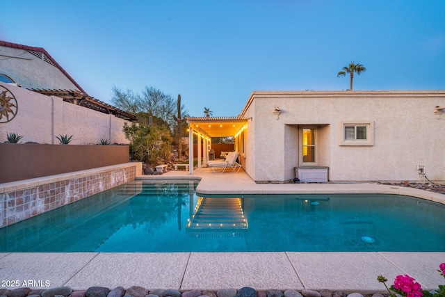 pool at dusk featuring a patio