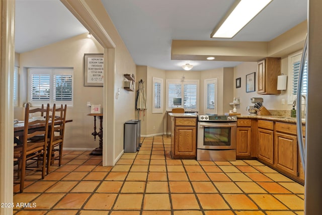 kitchen featuring light tile patterned floors, electric range, and kitchen peninsula