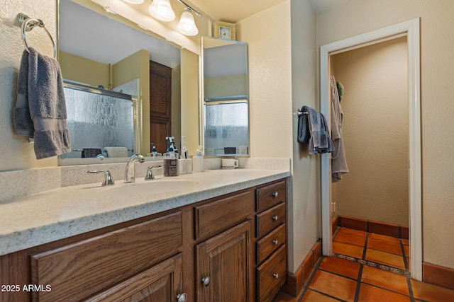 bathroom featuring vanity, tile patterned floors, and a shower