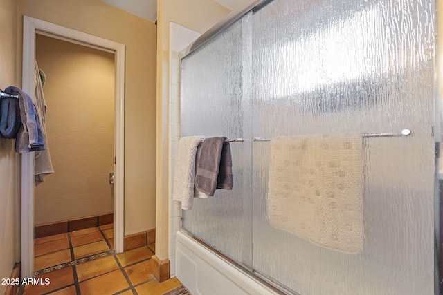 bathroom featuring tile patterned floors and combined bath / shower with glass door