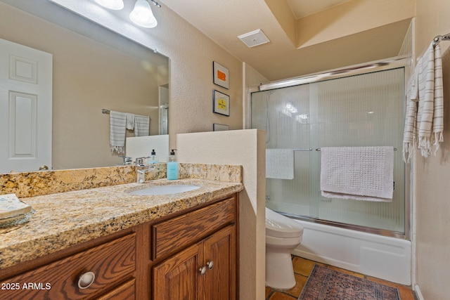 full bathroom with vanity, tile patterned floors, enclosed tub / shower combo, and toilet