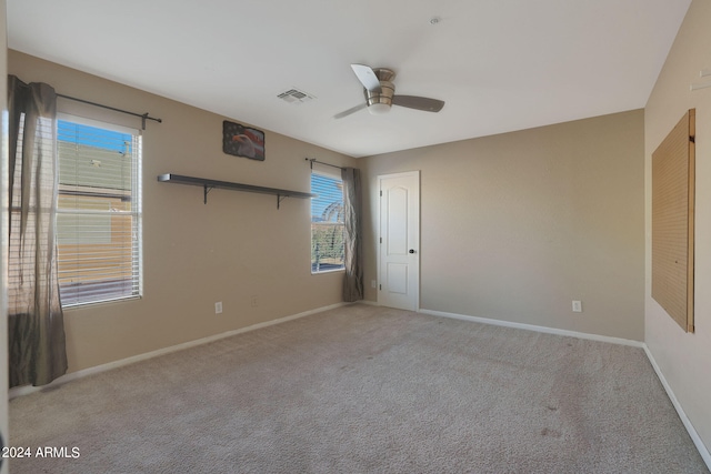 unfurnished bedroom with a closet, light colored carpet, and ceiling fan