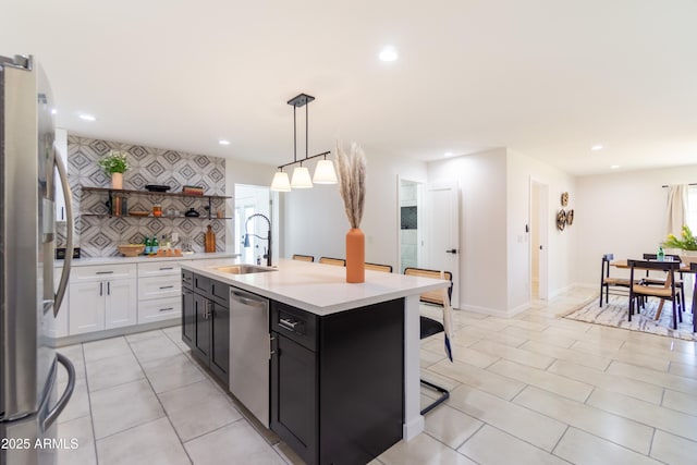 6907 E Palm Ln, Scottsdale, AZ 85257 - kitchen featuring stainless steel appliances, open shelves, light countertops, a kitchen bar, and a kitchen island with sink
