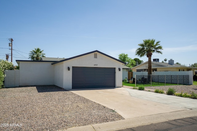 6907 E Palm Ln, Scottsdale, AZ 85257 - view of front of home featuring stucco siding, a garage, and concrete driveway