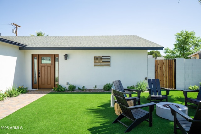 6907 E Palm Ln, Scottsdale, AZ 85257 - rear view of property featuring an outdoor fire pit, a shingled roof, and stucco siding