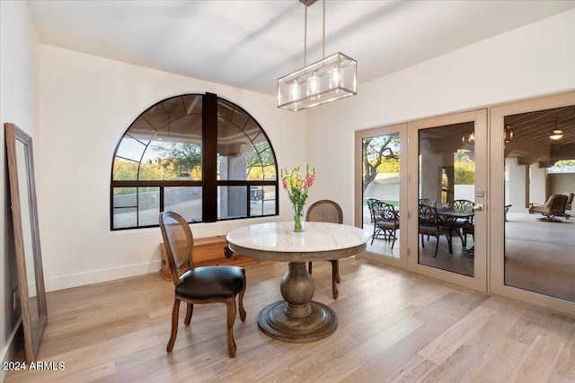 dining room featuring light hardwood / wood-style floors, french doors, and a notable chandelier