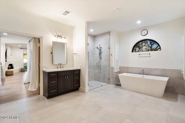 bathroom featuring vanity, tile patterned flooring, and plus walk in shower