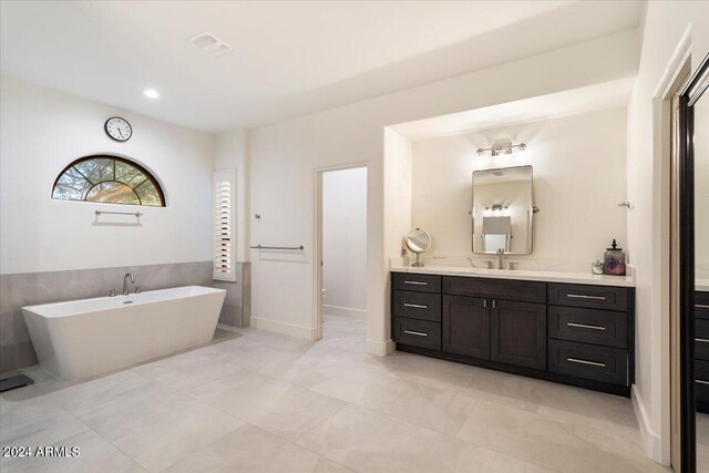 bathroom featuring a tub to relax in, tile patterned floors, and vanity