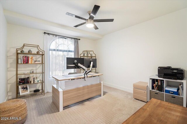 carpeted home office featuring ceiling fan