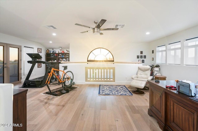 workout room featuring lofted ceiling, light wood-type flooring, and ceiling fan