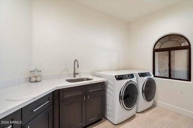 laundry area featuring sink, washing machine and dryer, and cabinets