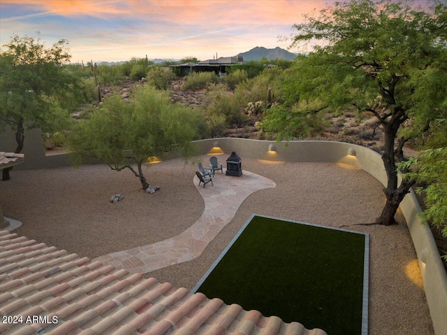 surrounding community with a mountain view, a fire pit, and a patio