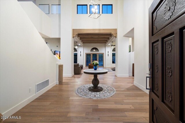 foyer with a towering ceiling and light wood-type flooring