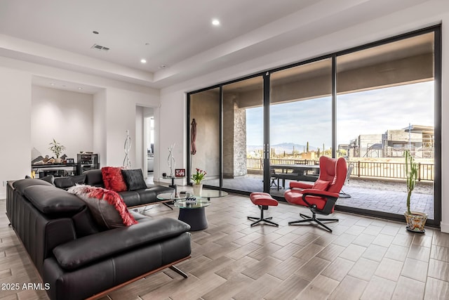 living room with light wood-style floors, visible vents, a city view, and recessed lighting