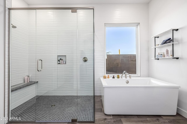 full bathroom featuring a stall shower and a freestanding bath