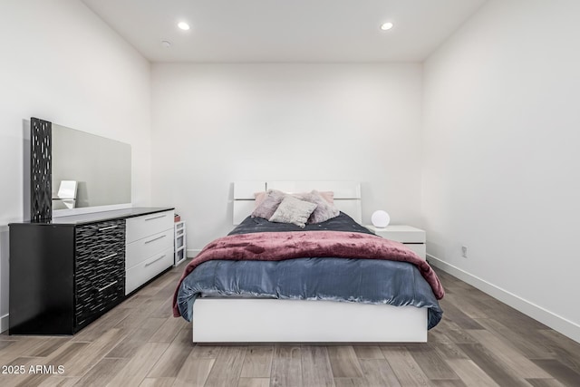 bedroom with light wood finished floors, baseboards, and recessed lighting