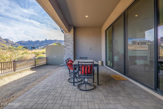 view of patio with a balcony and a mountain view