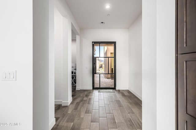 hall featuring light wood-style flooring, recessed lighting, visible vents, and baseboards