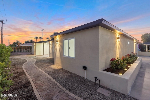 property exterior at dusk with a patio area