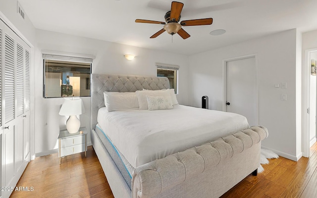 bedroom with hardwood / wood-style flooring, ceiling fan, and a closet